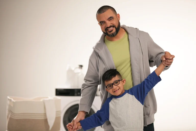 Joel, a cancer survivor, in the laundry room with his dad
